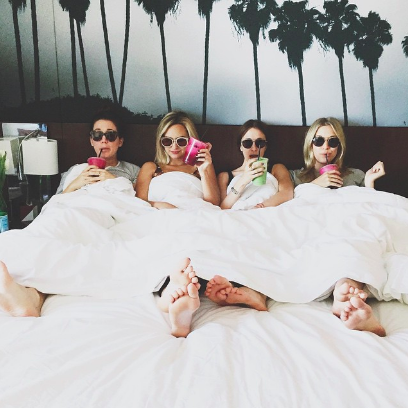 bachelorette party sipping drinks in bed