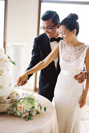 Bride and groom cutting wedding cake