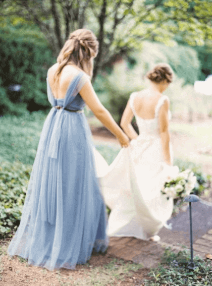 maid of honor holding bride's dress