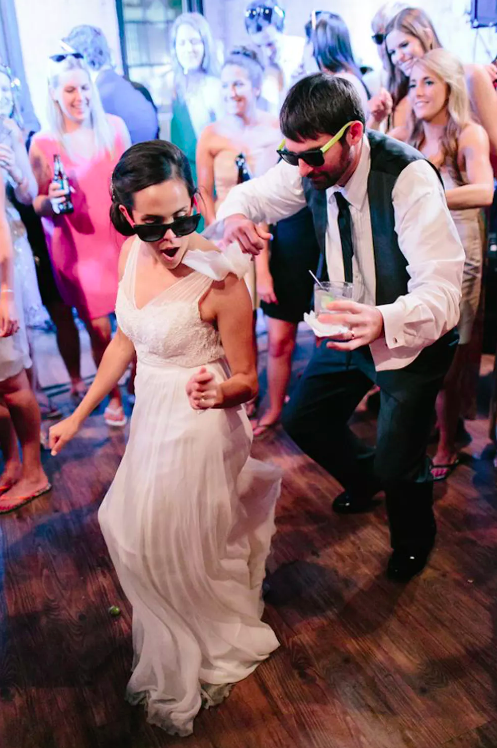 Bride and groom dancing with drinks in hand