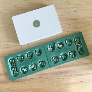 This is a green home decor by Swift and Stone called emerald green mancala game in standard