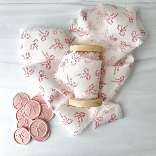 This is a pink holiday decorations by Honey Silks Co called bow 2" cotton ribbon and wax seal set in standard