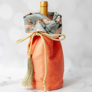 This is a multicolor wrapping paper by Courtney Bedi called velvet coral gift wine bottle bag with floral lining in standard