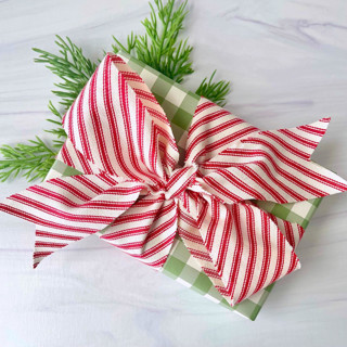 This is a red holiday decorations by Honey Silks Co called candy cane holiday cotton ribbon in standard
