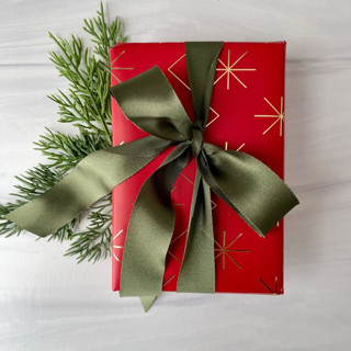 This is a green holiday decorations by Honey Silks Co called pine 1" x 15 ft holiday ribbon in standard
