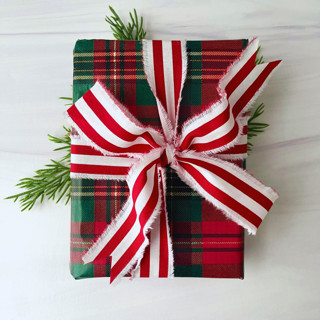 This is a red holiday decorations by Honey Silks Co called 1.5" hand frayed cotton stripe ribbon in standard