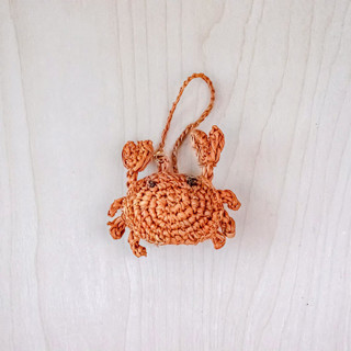 This is a orange back to school supplies by LIKHA called crab bag charm in standard