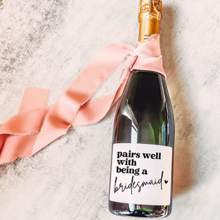This is a white bridesmaid gifts by The Pretty Little Mess called bridesmaid gift wine label | pairs well with being a bridesmaid in standard
