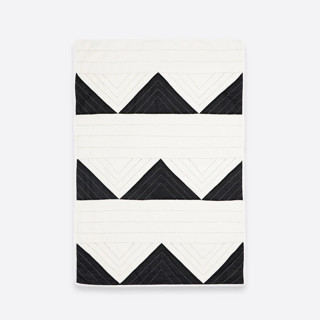 This is a black throw blankets by Anchal called small triangle quilt throw - charcoal in standard