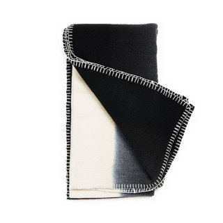 This is a black throw blankets by Anjali Purohit called ink black white ombre textured throw in hand spun merino and hand stitched hem in standard
