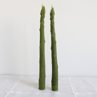 This is a green candles and candle holders by Happy Organics called asparagus taper beeswax candles pair in standard