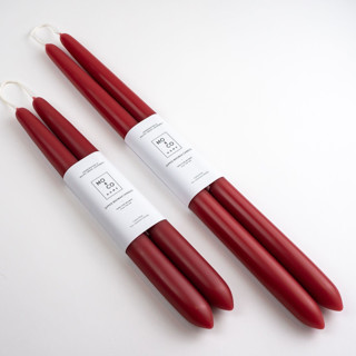 This is a red candles and candle holders by MoAndCo Home called 10 inch, berry red, dipped beeswax taper candles in standard