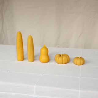This is a yellow candles and candle holders by Happy Organics called sweet maiz - harvest table bundle beeswax candles in standard