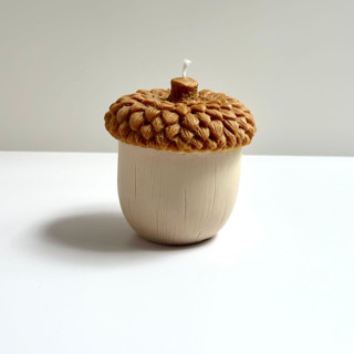 This is a multicolor candles and candle holders by Over By The Moon called brown and beige acorn candle in standard