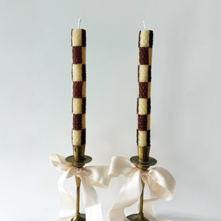 This is a brown candles and candle holders by Annie Shapiro called checkered taper candles (brown & beige) in standard
