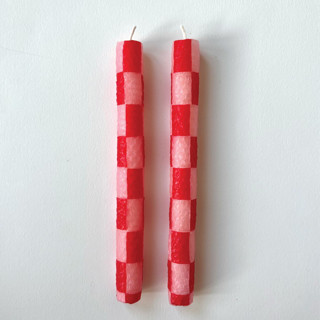 This is a pink candles and candle holders by Annie Shapiro called red and pink checkered candles in standard