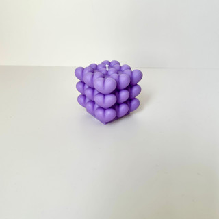 This is a purple candles and candle holders by Over By The Moon called purple cubed hearts candle in standard