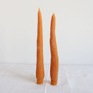 This is a orange candles and candle holders by Happy Organics called carrot beeswax taper candle pair in standard