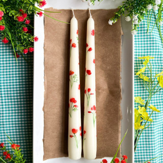 This is a beige candles and candle holders by Emily de Moraes called set of 2 california poppy hand-painted taper candles in standard