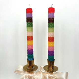 This is a red candles and candle holders by Annie Shapiro called rainbow stripe taper candles in standard