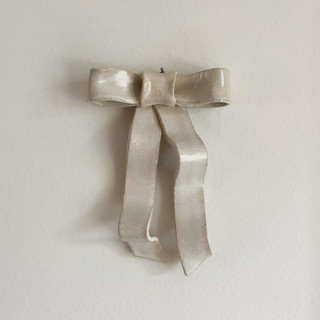This is a white decorative objects by Sidney Field called ceramic wall ribbon bow - tall in standard