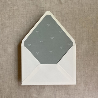 This is a green wedding envelopes by Ivory Invitations called sage baby ribbon bows envelope liner for a7 euro flap envelope | pack of 10 in standard