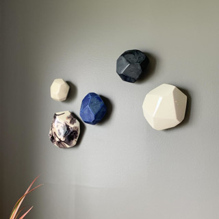 This is a multicolor sculpture art by Lauren Herzak Bauman called 5 geo wall stones in white, azul, and nebula in standard