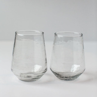 This is a clear tableware by Powered By People called handblown hammered glass water tumbler - clear - set of 4 in standard