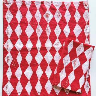 This is a red tableware by Julie Peach called block printed diamond dinner napkins in standard