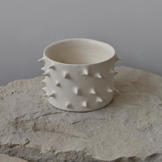 This is a beige accent pieces by OWO Cerámica called spikes white ceramic handmade plant pot in standard