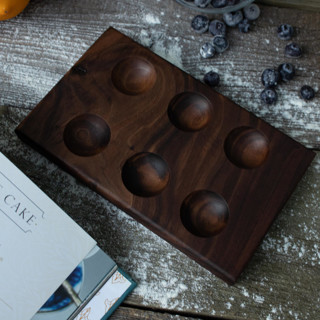 This is a brown tableware by Block and Bowl called walnut 6-egg holder in standard