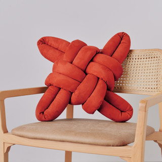 This is a red throw pillows by Knots Studio called red earth vegan suede knot pillow in standard