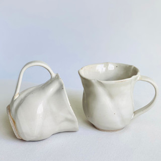 This is a beige tableware by Cloude Made called ecru tulip mugs in standard