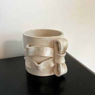 This is a white tableware by Sidney Field called ribbon bow mug in standard