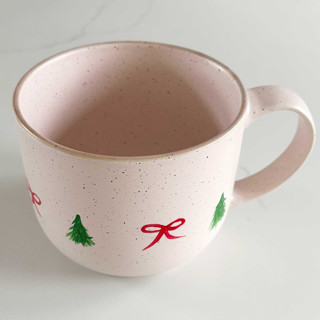 This is a pink tableware by Nicoletta Savod called hand-painted blush stoneware mug with illustrated christmas trees and bows, red and green in standard