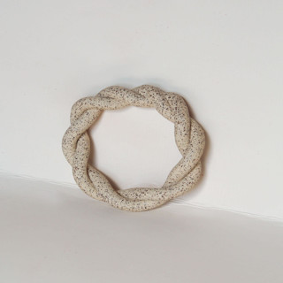 This is a beige tableware by Virginia Felix called speckled napkin ring in standard