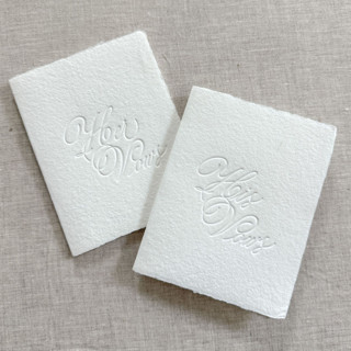 This is a white vow books by Maria Ferrer G. called debossed print vow books - set of 2 in standard