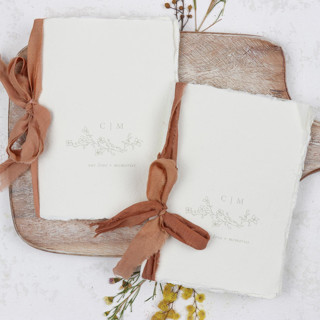 This is a beige vow books by Clove and Cedar Design called beige floral monogram vow book | set of 2 | size 6x4.125 in standard