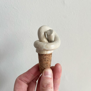 This is a white tableware by Sidney Field called knot wine topper in standard