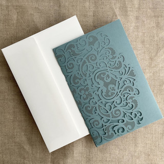 This is a blue vellum wedding invitations by Ivory Invitations called dust blue lace lasercut pocket | pack of 10 | envelopes included in standard
