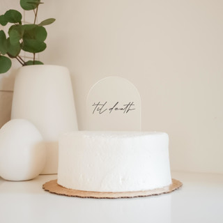 This is a clear wedding cake toppers by Toaste called "'til death" arch acrylic cake topper - black ink in standard