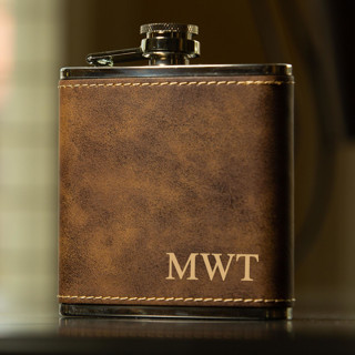 This is a brown groomsmen gifts by Great Little Favor Co called custom engraved rustic brown initials flask in standard