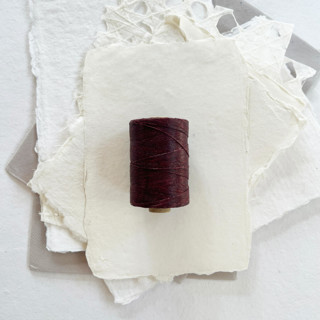 This is a red wedding ribbon by Jenny Sanders called maroon waxed linen twine, 2-ply in standard
