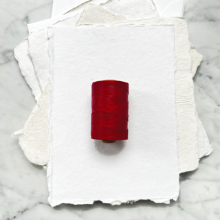 This is a red wedding ribbon by Jenny Sanders called cherry red waxed linen twine, 2-ply in standard