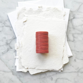This is a orange wedding ribbon by Jenny Sanders called coral waxed linen twine, 2-ply in standard