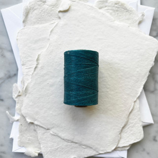 This is a blue wedding ribbon by Jenny Sanders called peacock blue waxed linen twine, 2-ply in standard