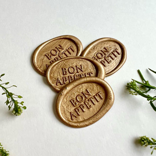 This is a gold wax seals by Eva Tadros called bon appétit menu wax seal sticker_antique gold, pack of 10 in standard
