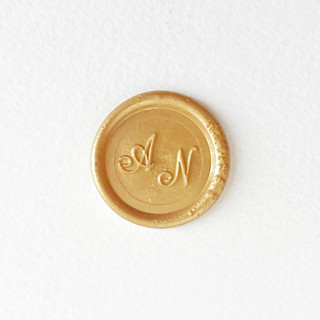 This is a gold wax seals by Self Stationery called custom color and initials self adhesive wax seal sticker | set of 10 in standard