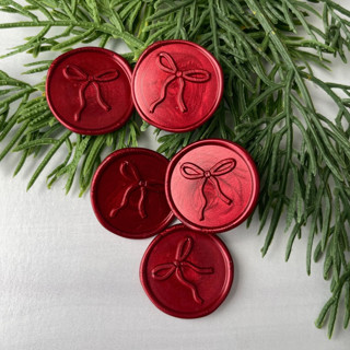 This is a red wax seals by Honey Silks Co called bow red wax seal - set of 10 in standard