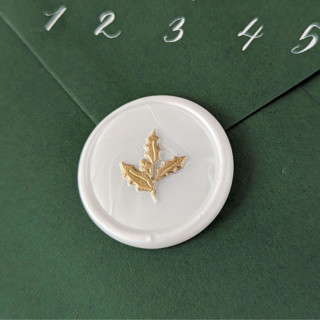 This is a white wax seals by Inkspiringletters called holly- holiday wax seals- set of 25 hand-crafted white wax seals in standard